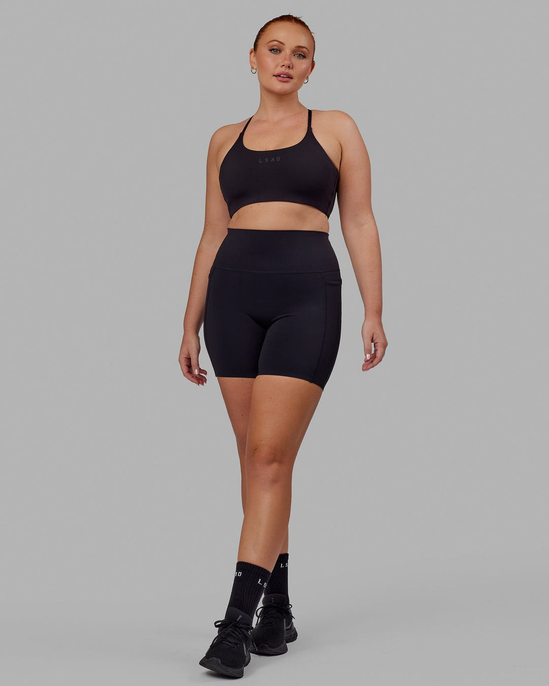Woman wearing Elixir Mid Short Tight with Pockets - Black