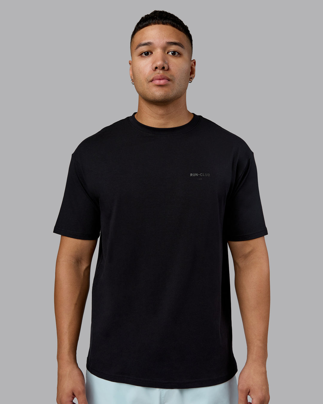 Man wearing RUN CLUB FLXCotton Tee Oversize - Black-Reflective | Model:Kaelyb | Size:L