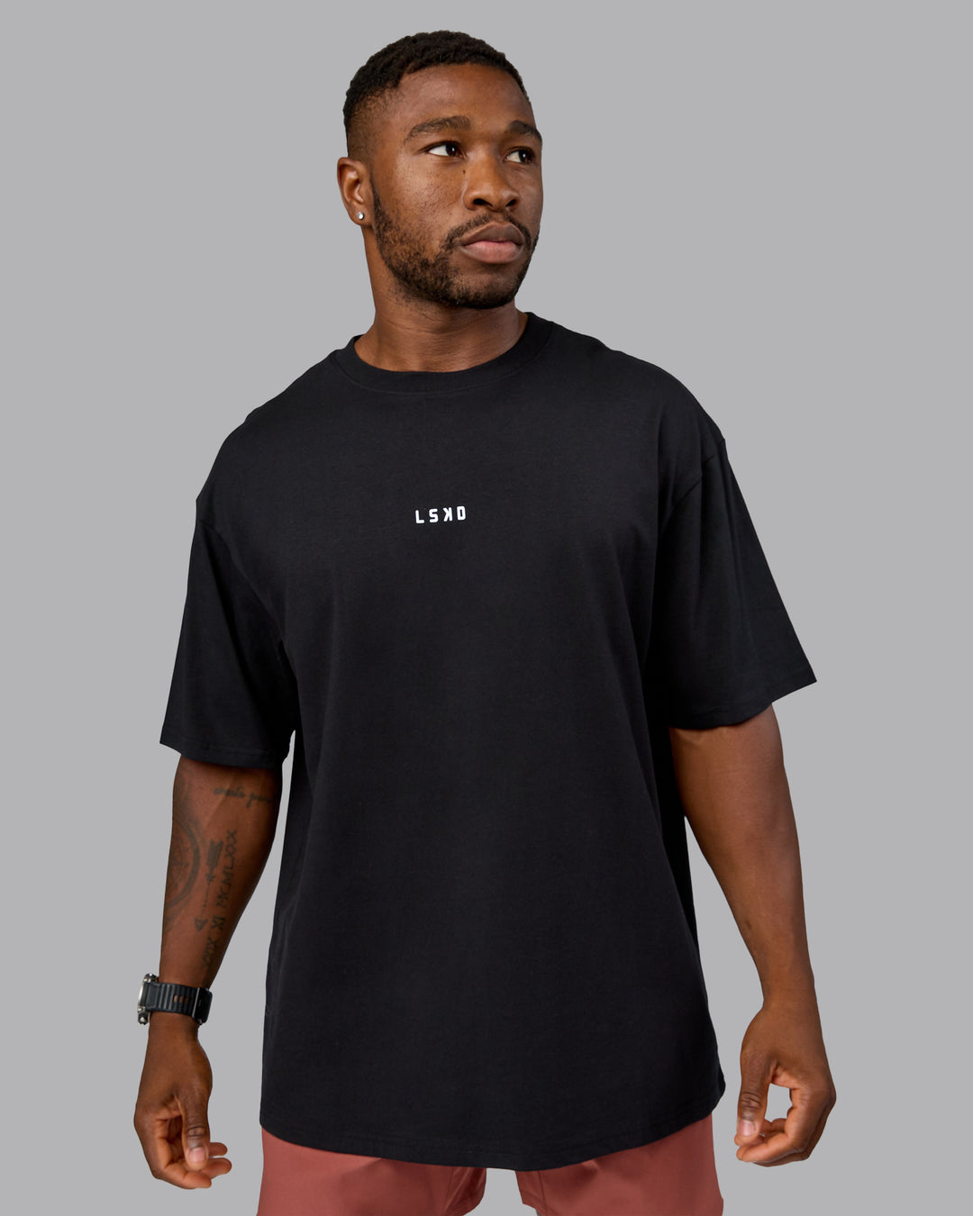 Man wearing On Repeat FLXCotton Oversized Tee - Black-Mahogany | Model:Sam | Size:L