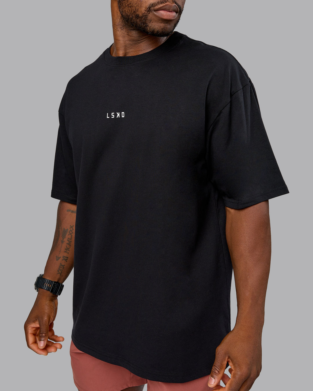 Man wearing On Repeat FLXCotton Oversized Tee - Black-Mahogany | Model:Sam | Size:L