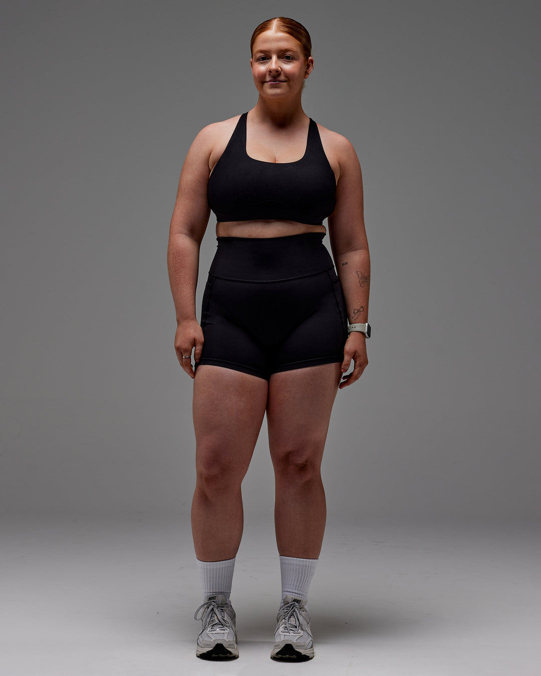 Woman wearing Fusion Ultra High-Rise 4" Short Pockets - Black | Model:Caity | Size:M