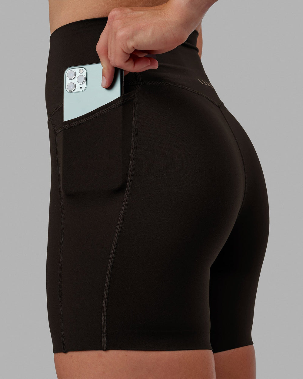 Woman wearing Elixir Mid Short Tights with Pockets - Dark Walnut