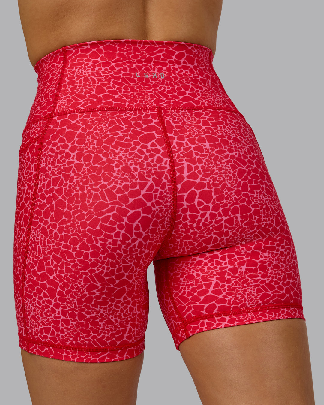 Woman wearing Fusion Ultra High-Rise 6" Short Pockets - Red Vitality Print | Model:Halle | Size:S