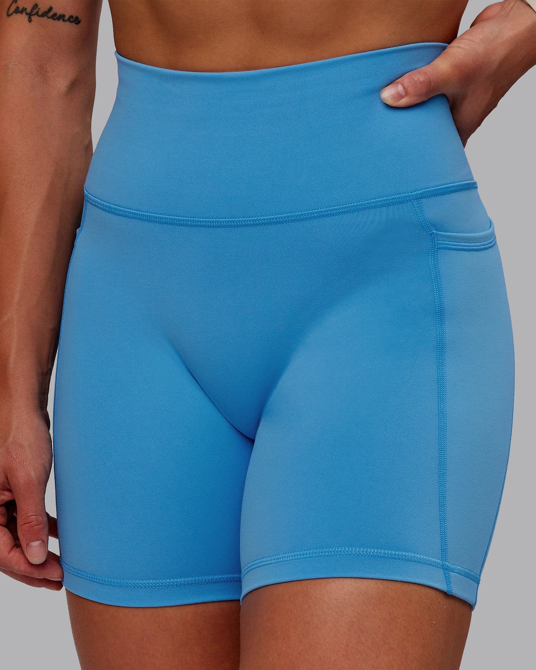 Woman wearing Fusion Ultra High-Rise 6" Short Pockets - Azure Blue | Model:Amber | Size:S