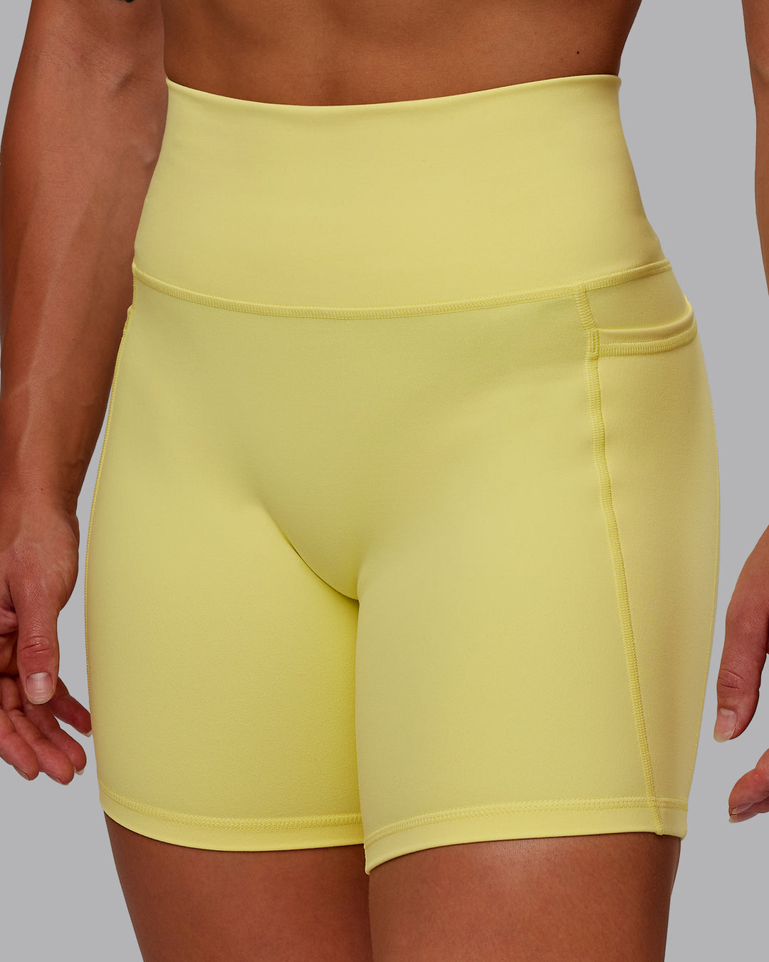 Woman wearing Fusion Ultra High-Rise 6" Short Pockets - Lemon Fizz | Model:Amber | Size:S