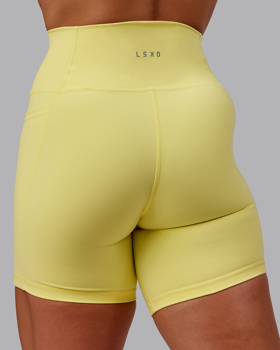Woman wearing Fusion Ultra High-Rise 6" Short Pockets - Lemon Fizz | Model:Amber | Size:S