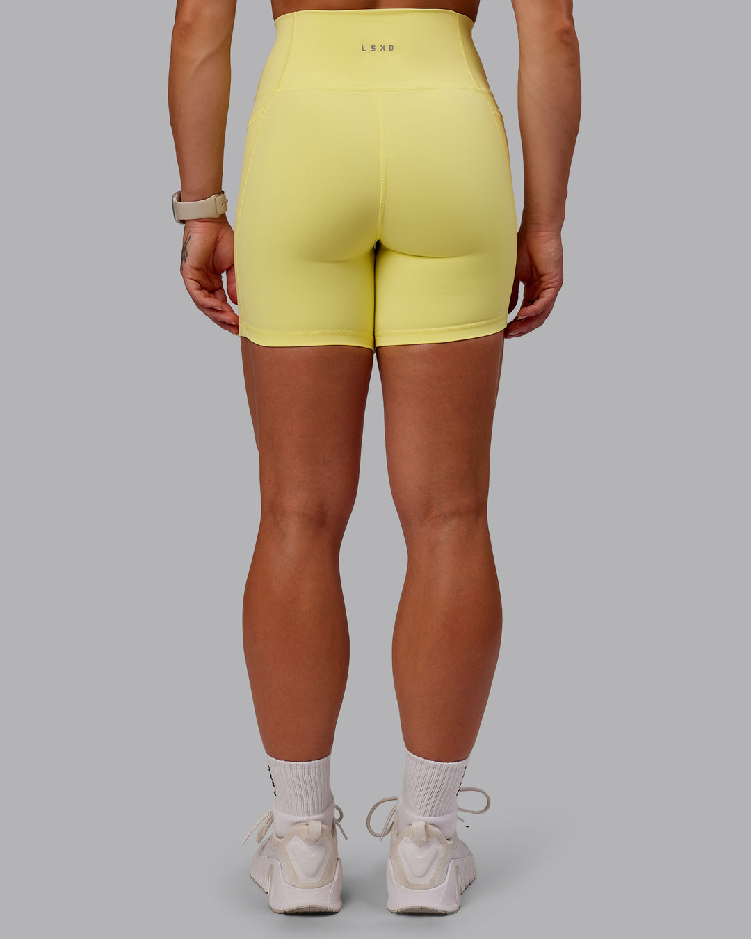 Woman wearing Fusion Ultra High-Rise 6" Short Pockets - Lemon Fizz | Model:Amber | Size:S