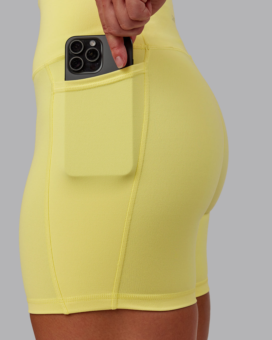Woman wearing Fusion Ultra High-Rise 6" Short Pockets - Lemon Fizz | Model:Amber | Size:S