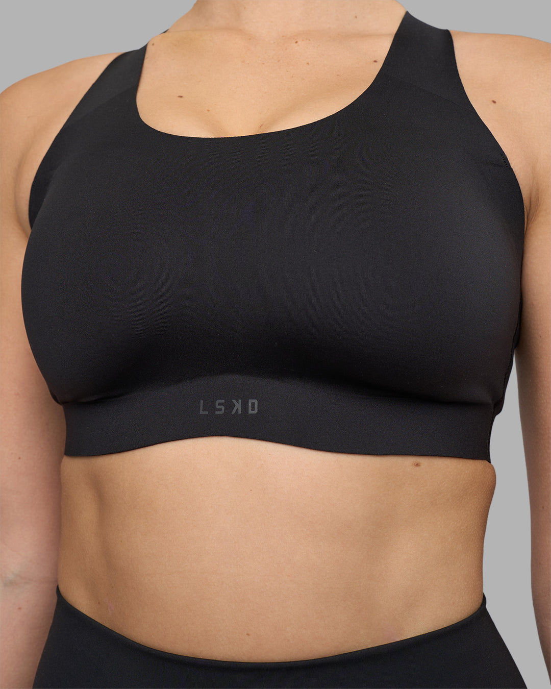 Woman wearing Stability Sports Bra - Black | Model:Amy | Size:S (D-E Cup)