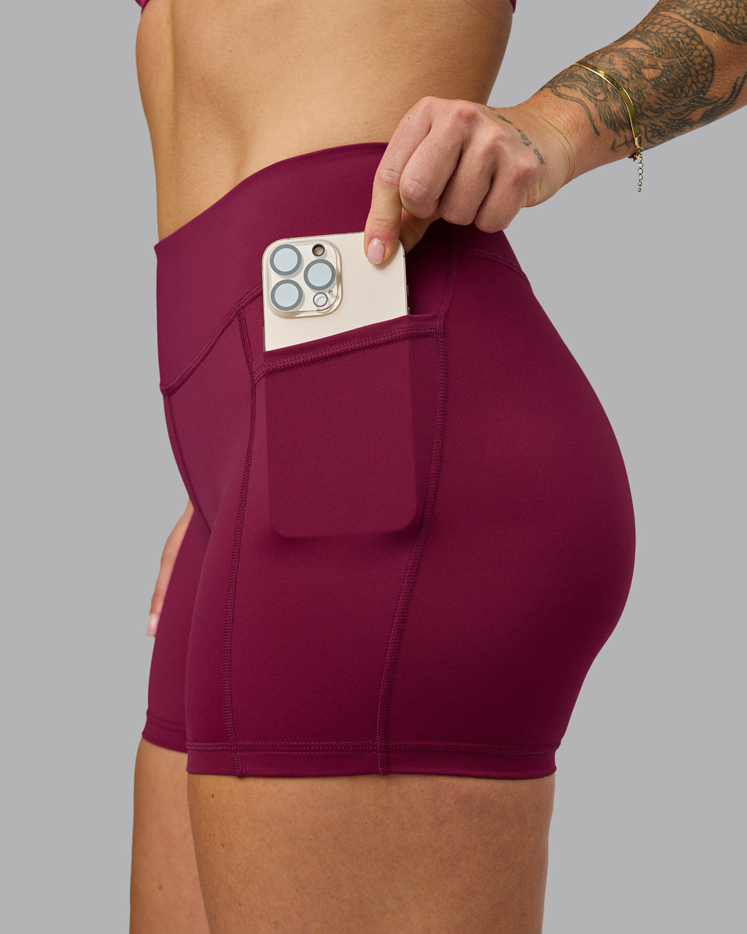 Woman wearing Elite High-Rise 4" Short Pockets - Plum Berry | Model:Robyn | Size:S