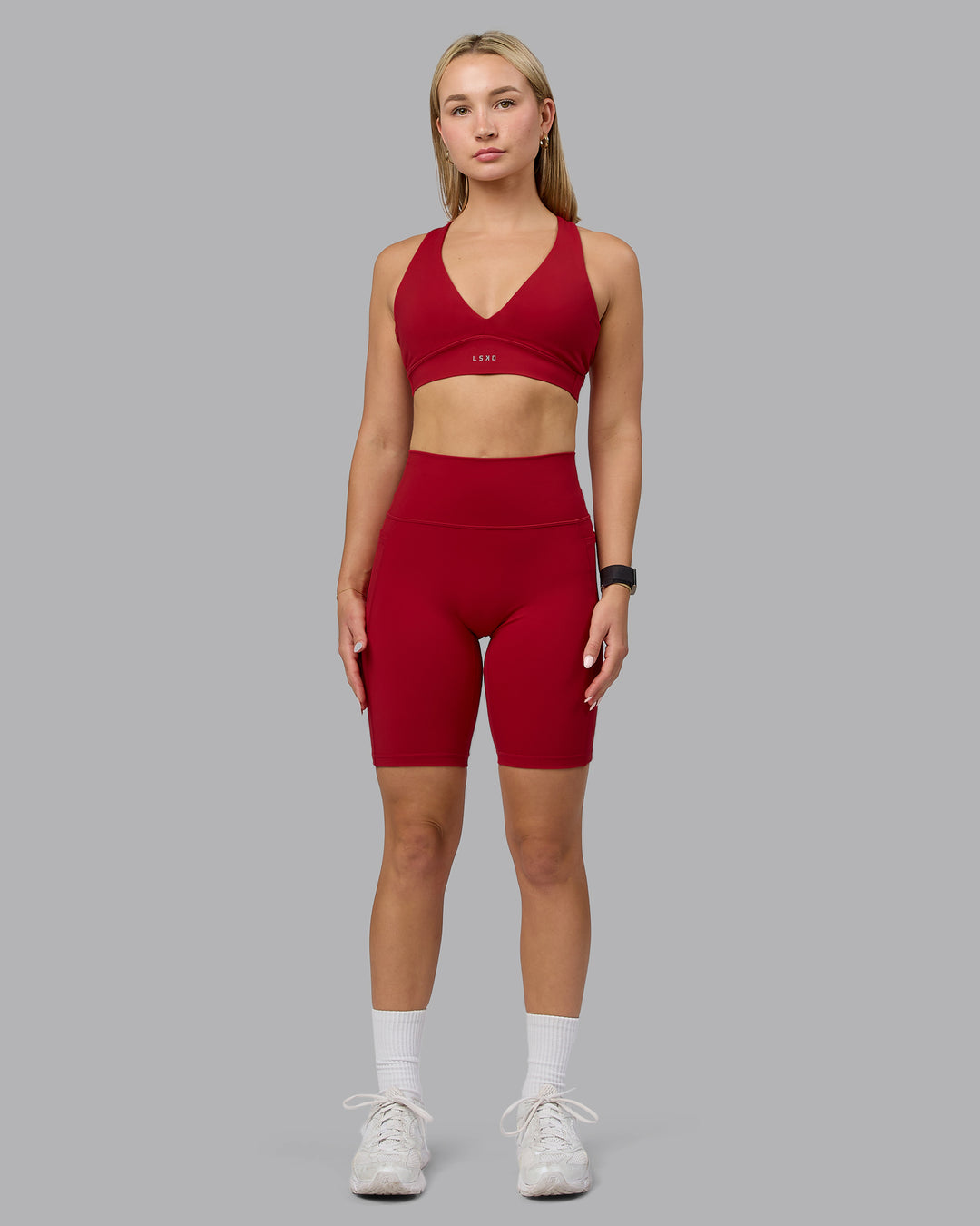 Woman wearing Fusion Ultra High-Rise 9" Short Pockets - Cherry Red | Model:Halle | Size:S