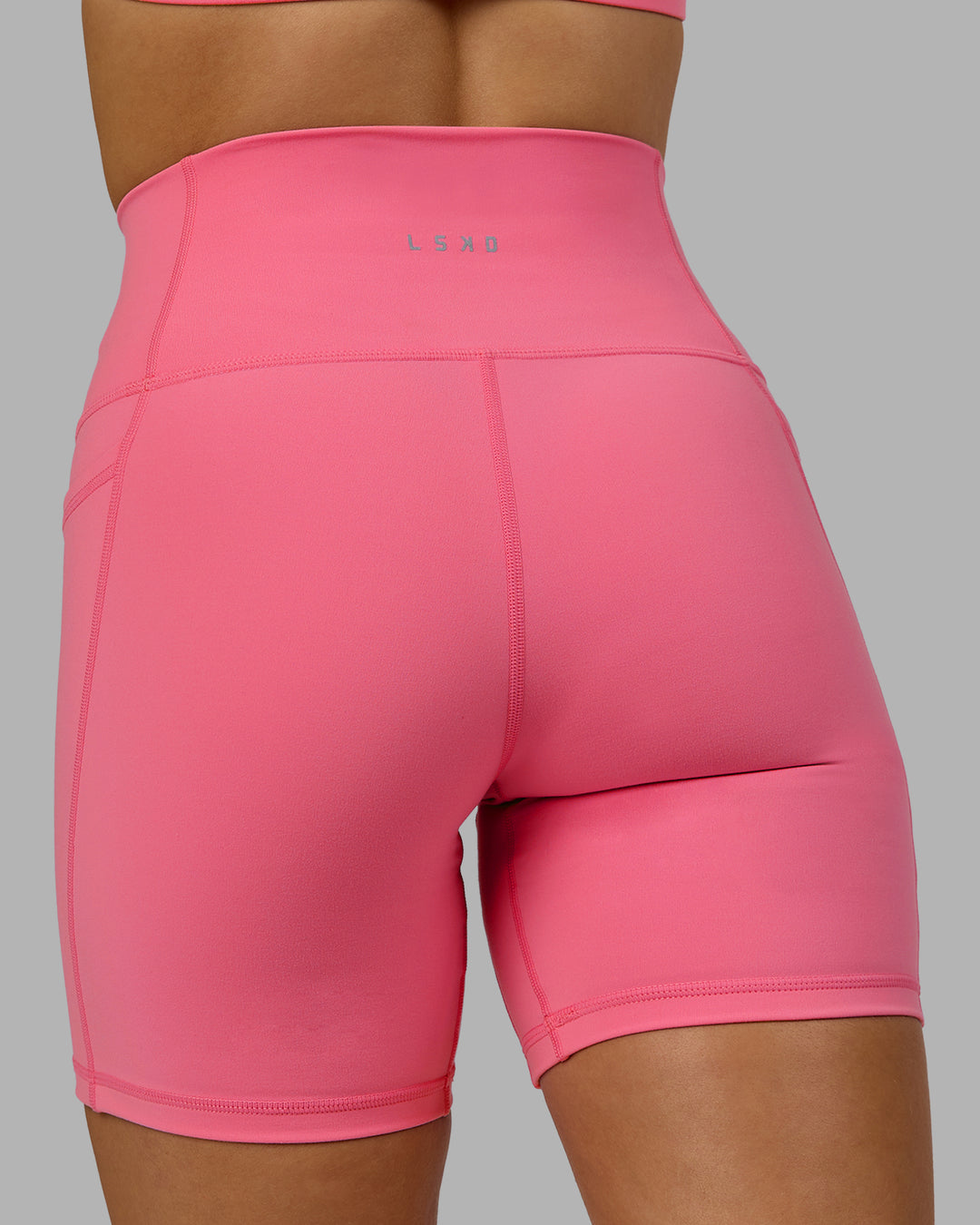 Woman wearing Fusion Ultra High-Rise 6" Short Pockets - Pink Lemonade | Model:Halle | Size:S
