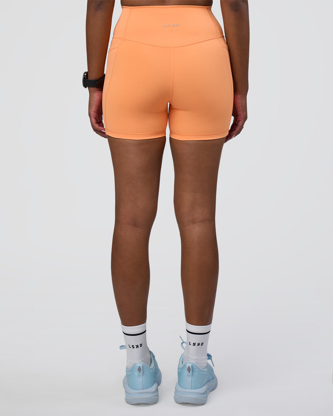 Woman wearing Fusion Ultra High-Rise 4" Short Pockets - Cantaloupe | Model:Rica | Size:S