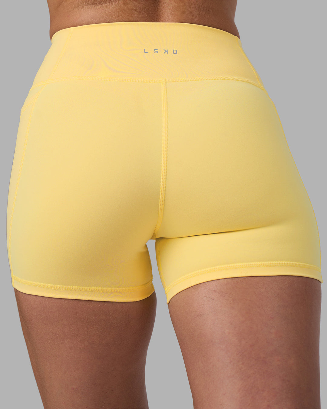 Woman wearing Fusion Ultra High-Rise 4" Short Pockets - Lemon | Model:Sophie | Size:S