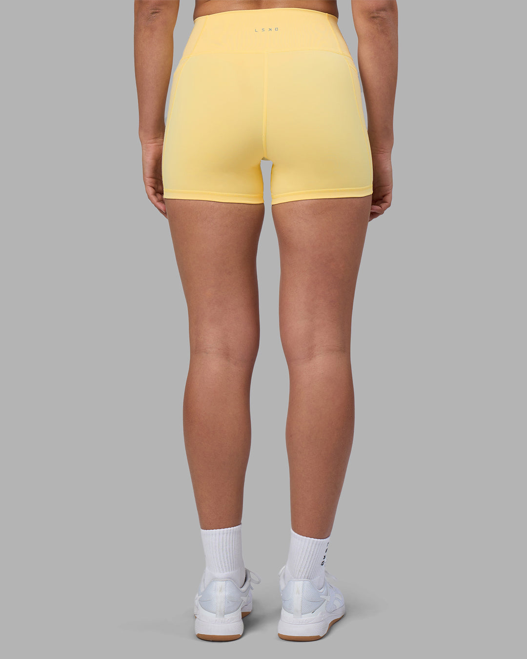 Woman wearing Fusion Ultra High-Rise 4" Short Pockets - Lemon | Model:Sophie | Size:S