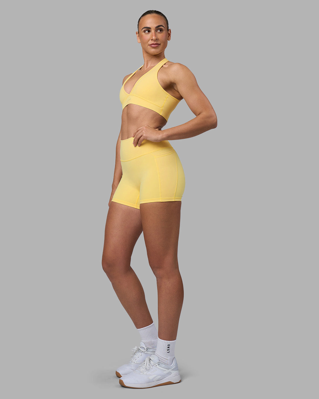 Woman wearing Fusion Ultra High-Rise 4" Short Pockets - Lemon | Model:Sophie | Size:S