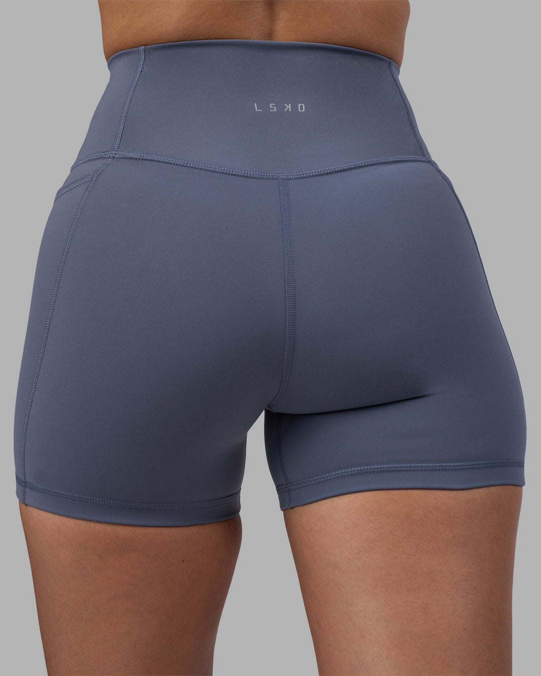 Woman wearing Fusion Ultra High-Rise 4" Short Pockets - Night Shadow | Model:Rhiley | Size:S