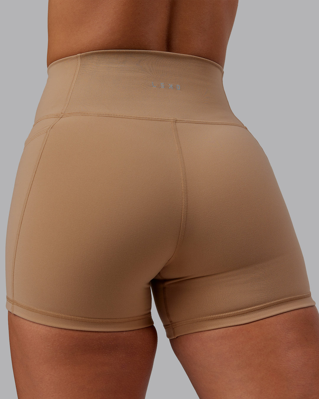 Woman wearing Fusion Ultra High-Rise 4" Short Pockets - Warm Smoke | Model:Lyss | Size:S