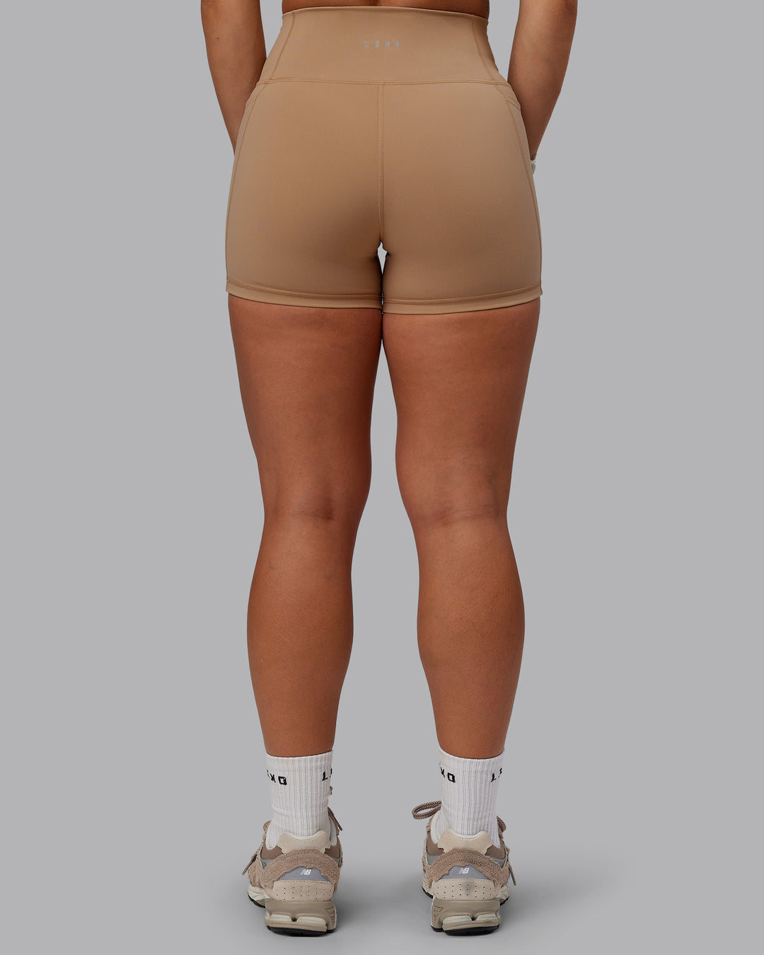 Woman wearing Fusion Ultra High-Rise 4" Short Pockets - Warm Smoke | Model:Lyss | Size:S
