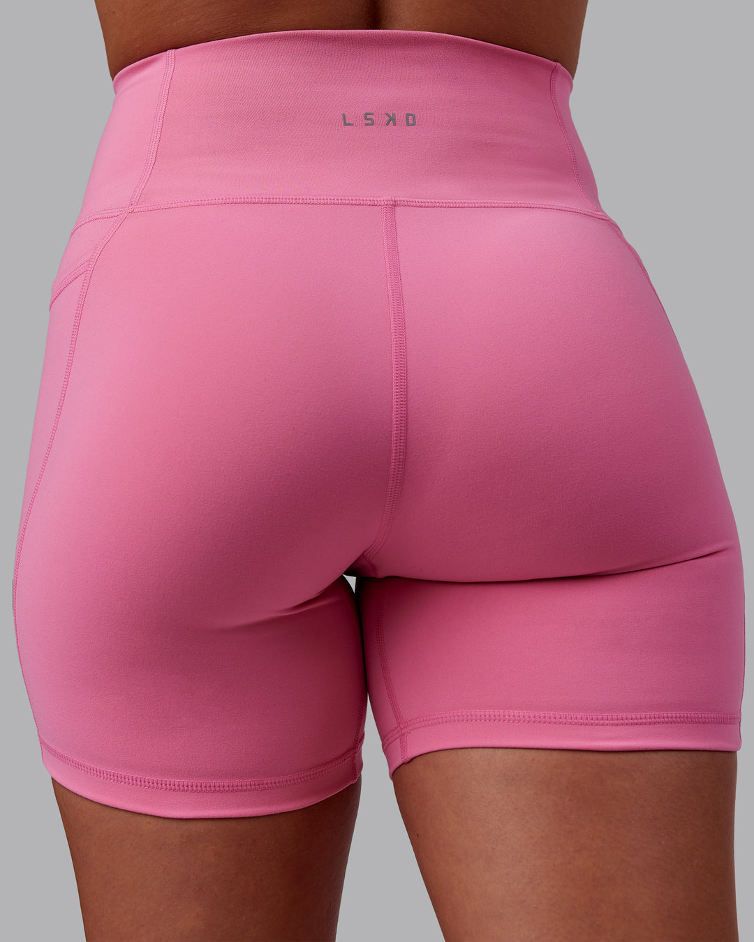 Woman wearing Fusion Ultra High-Rise 6" Short Pockets - Candy Pink | Model:Charlize | Size:S