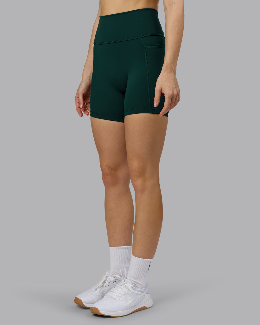 Woman wearing Fusion Ultra High-Rise 6" Short Pockets - Dark Moss | Model:Emilie | Size:S