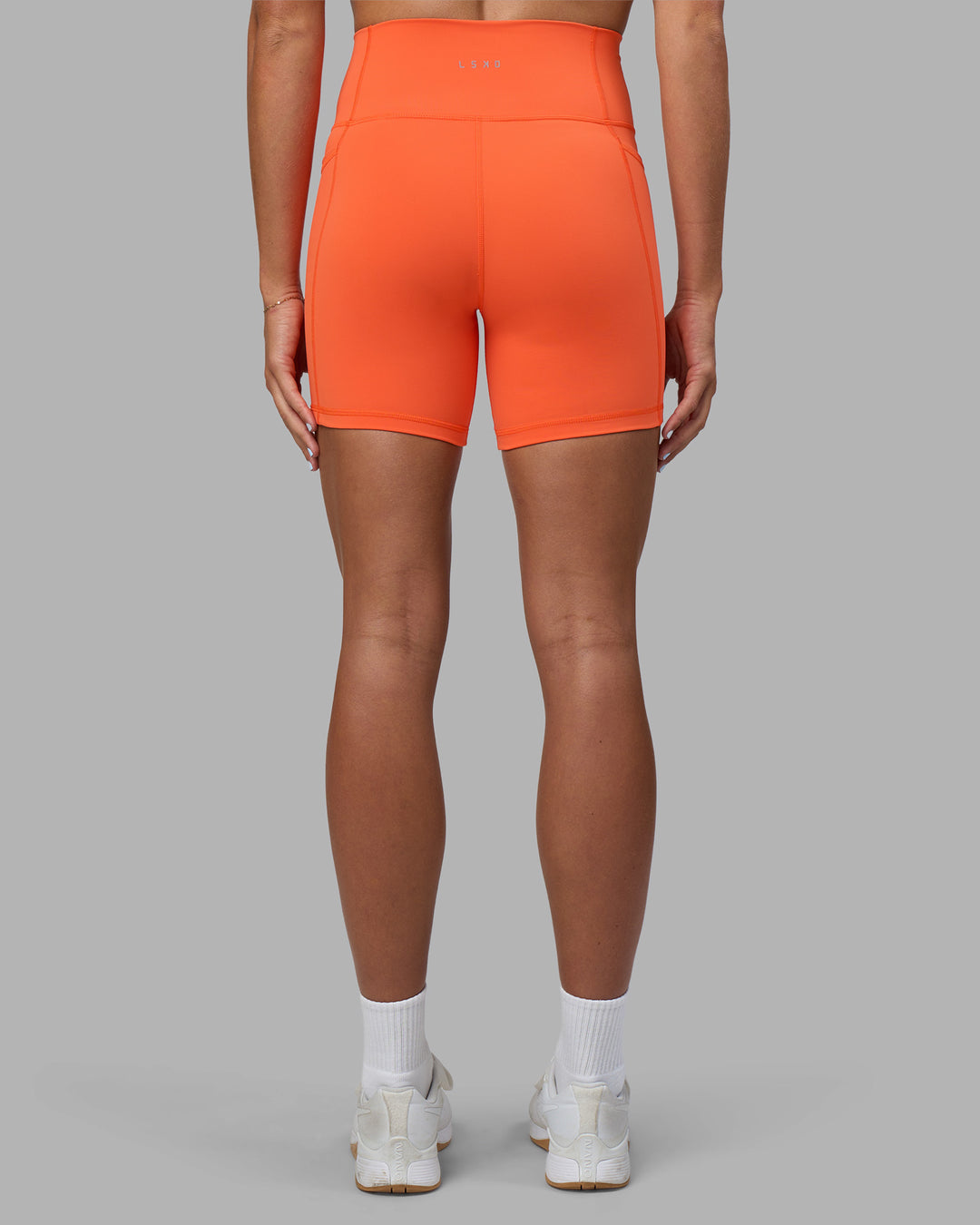 Woman wearing Fusion Ultra High-Rise 6" Short Pockets - Ultra Orange | Model:Katie | Size:S