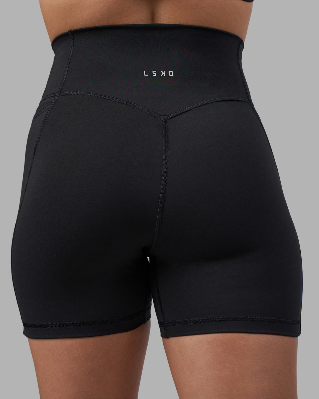Woman wearing Fusion V-Contour Ultra High-Rise 4โ Short Pockets - Black | Model:Charlize | Size:S