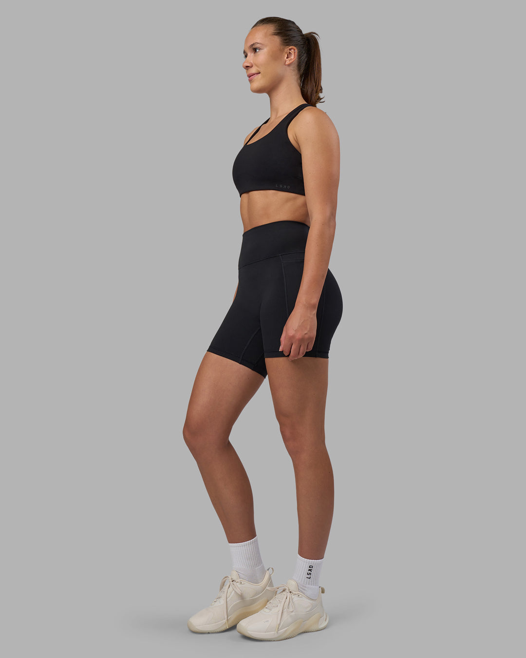 Woman wearing Fusion V-Contour Ultra High-Rise 6" Short Pockets - Black | Model:Charlize | Size:S
