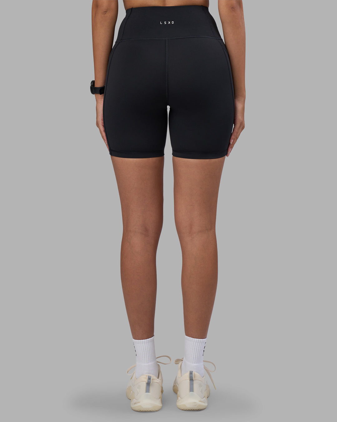 Woman wearing Rep Ultra High-Rise 6" Short Pockets - Black-Power Cobalt | Model:Rhiley | Size:S