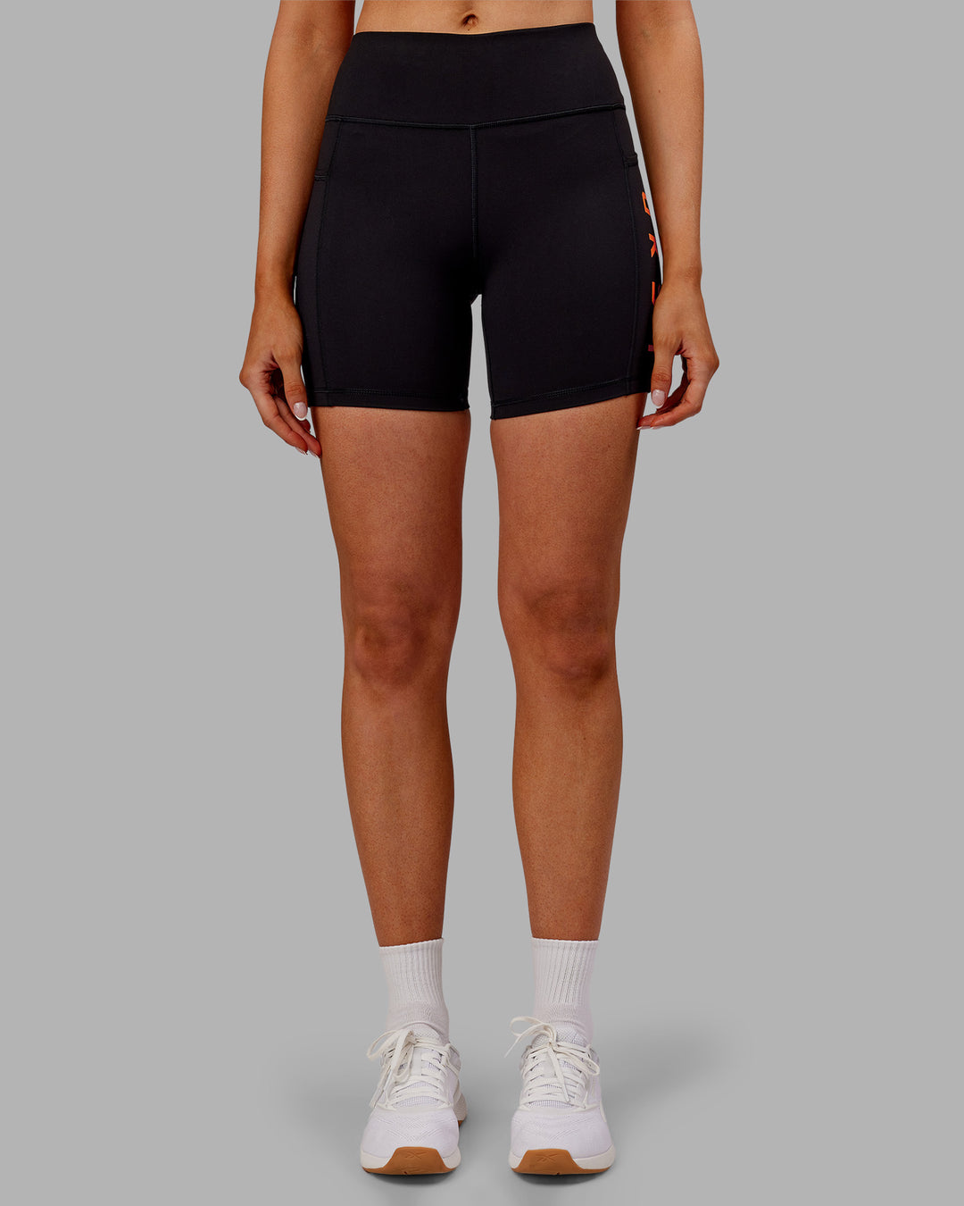 Woman wearing Rep Ultra High-Rise 6" Short Pockets - Black-Ultra Orange | Model:Ella | Size:S