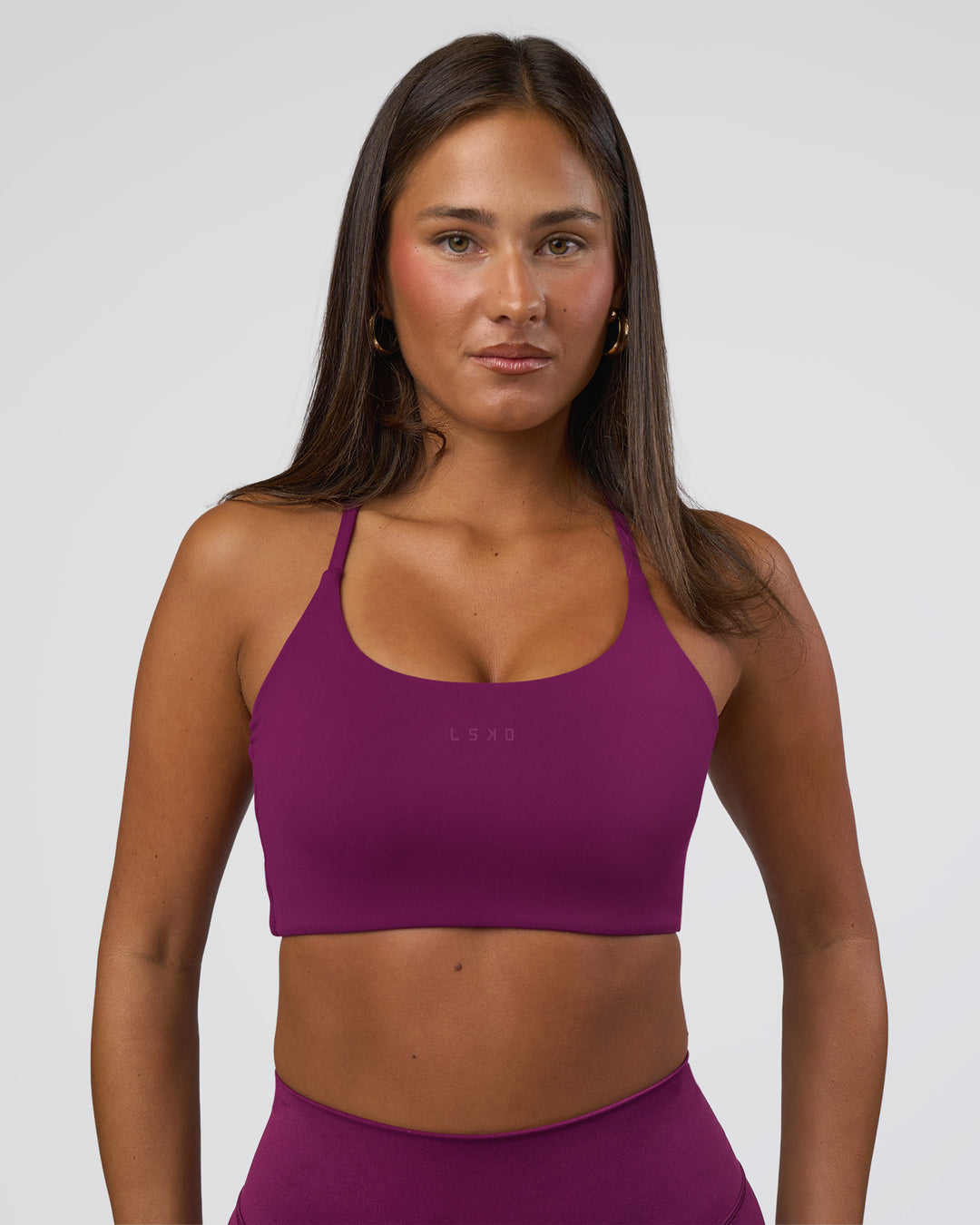 Woman wearing Twist Sports Bra - Plum Caspia | Model:Bianca | Size:S