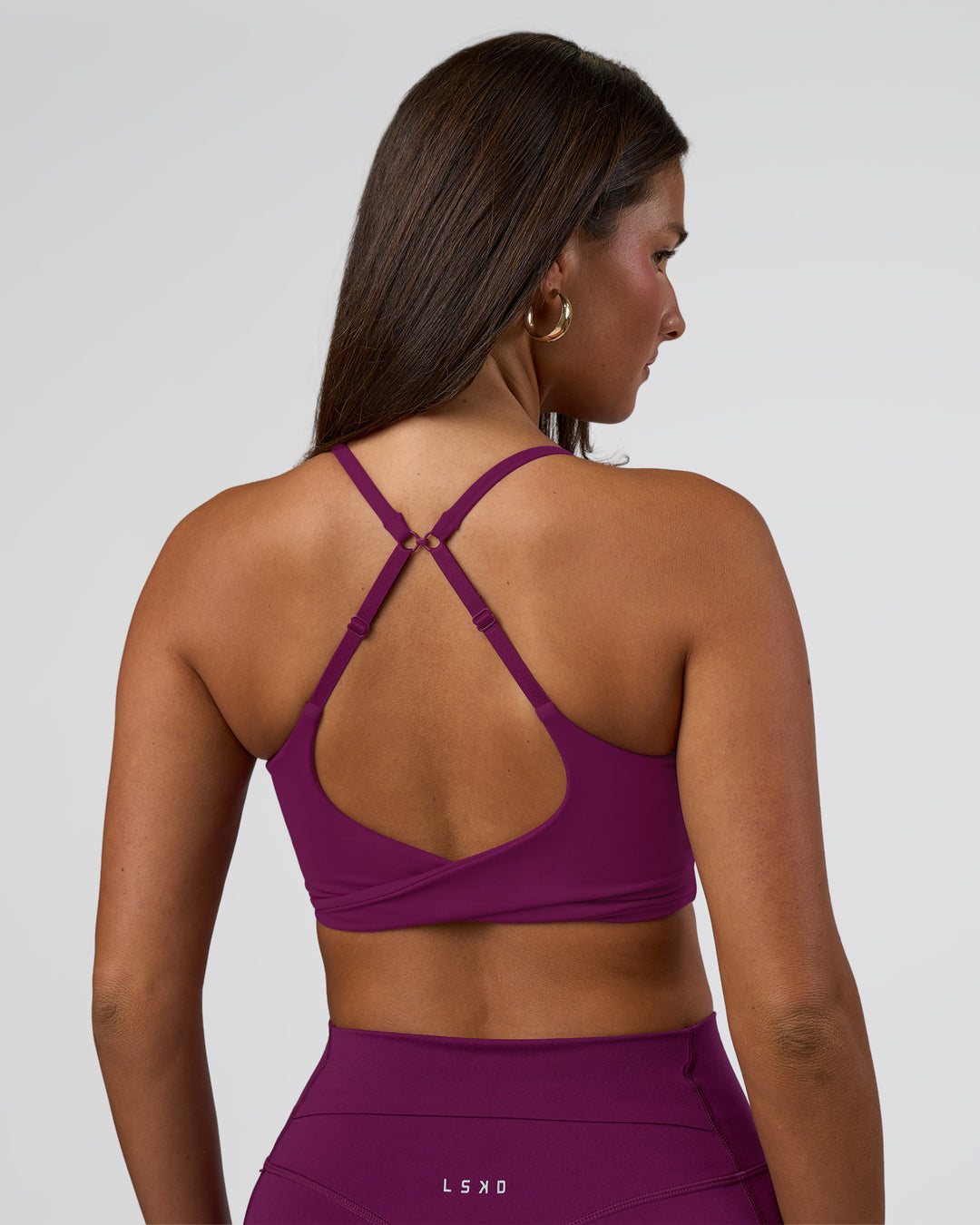 Woman wearing Twist Sports Bra - Plum Caspia | Model:Bianca | Size:S