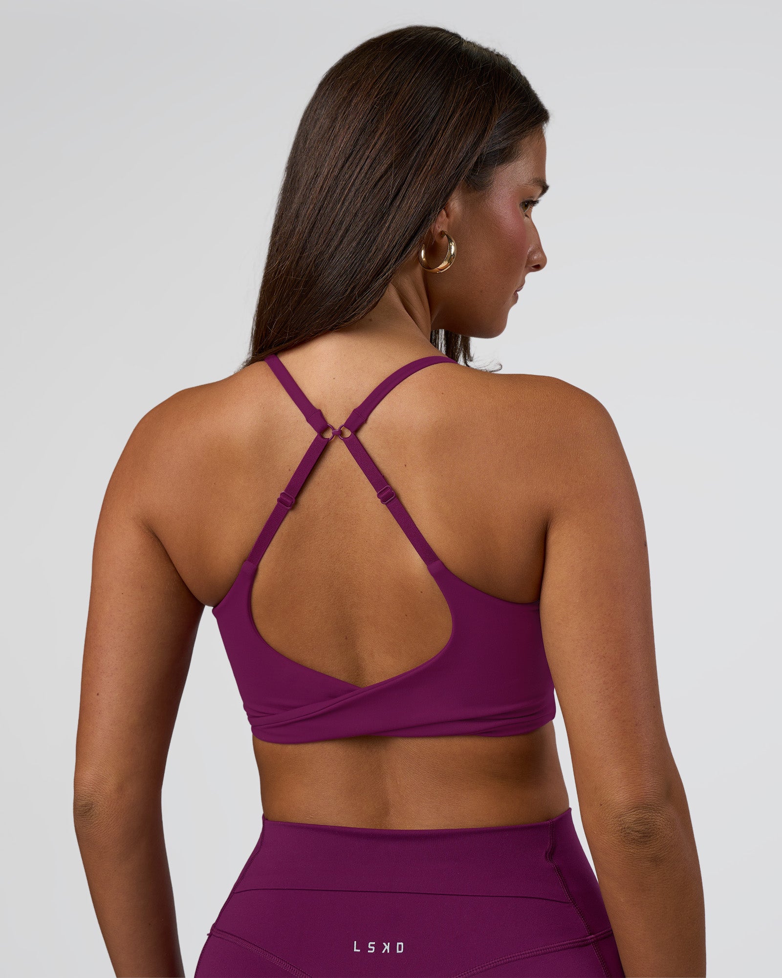 Woman wearing Twist Sports Bra - Plum Caspia | Model:Bianca | Size:S