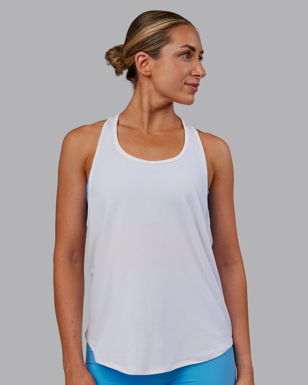Woman wearing AeroFLX+ Drop Armhole Seamless Tank - White | Model:Paris | Size:S