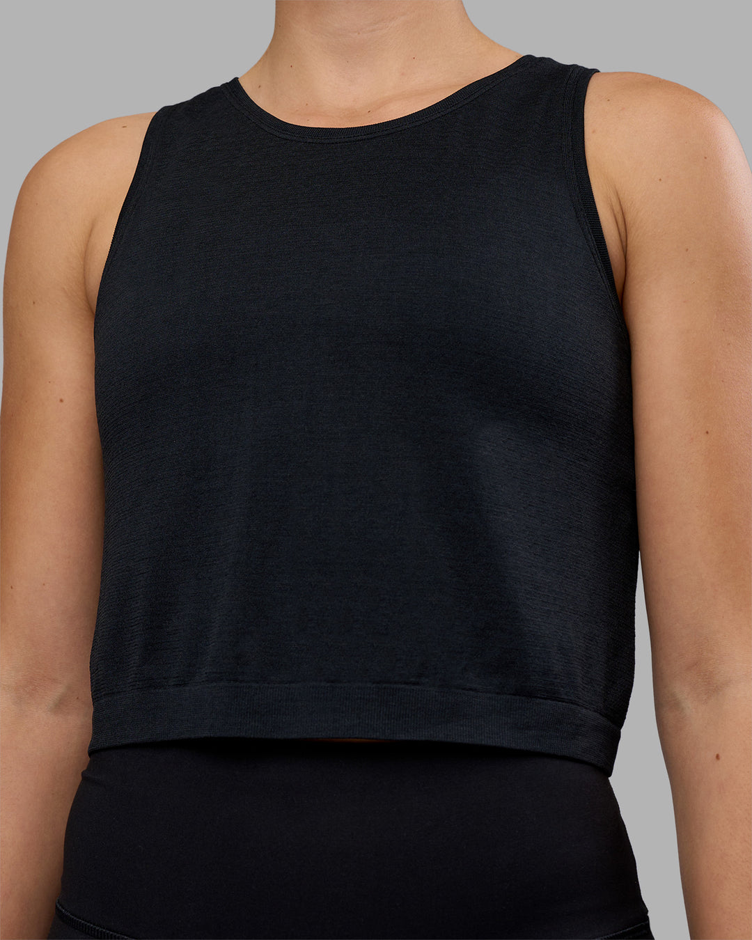 Woman wearing AeroFLX+ Seamless Skimmer Tank - Black Marl | Model:Charlize | Size:S