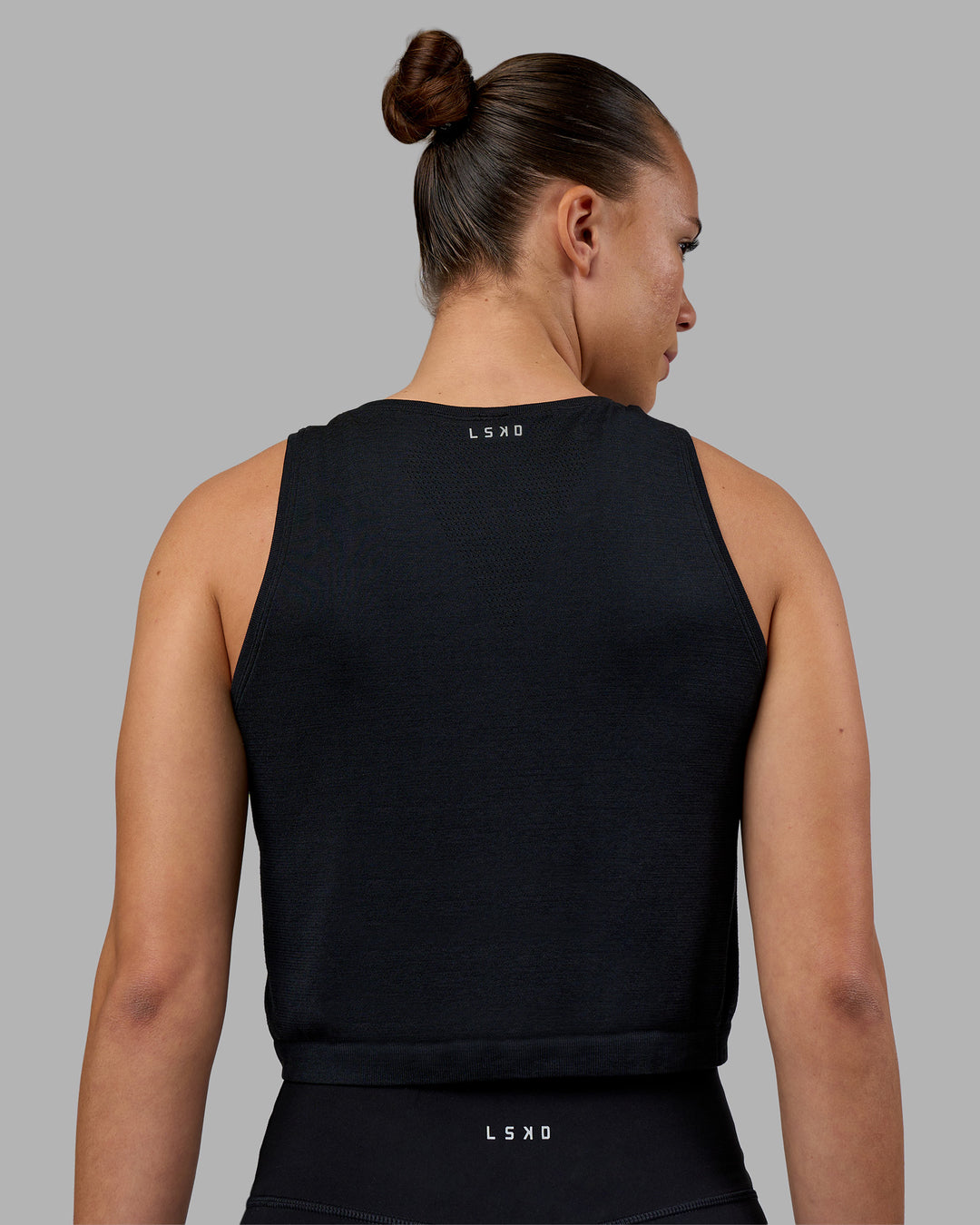 Woman wearing AeroFLX+ Seamless Skimmer Tank - Black Marl | Model:Charlize | Size:S