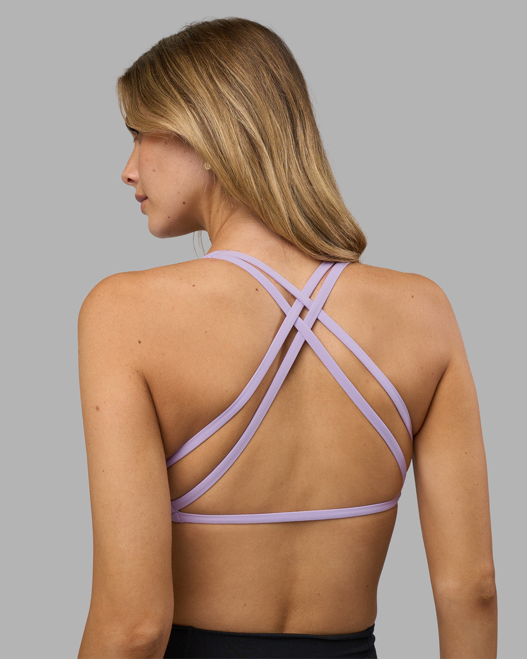 Woman wearing Aspire Twist Sports Bra - Pale Lilac | Model:Leilani | Size:XS