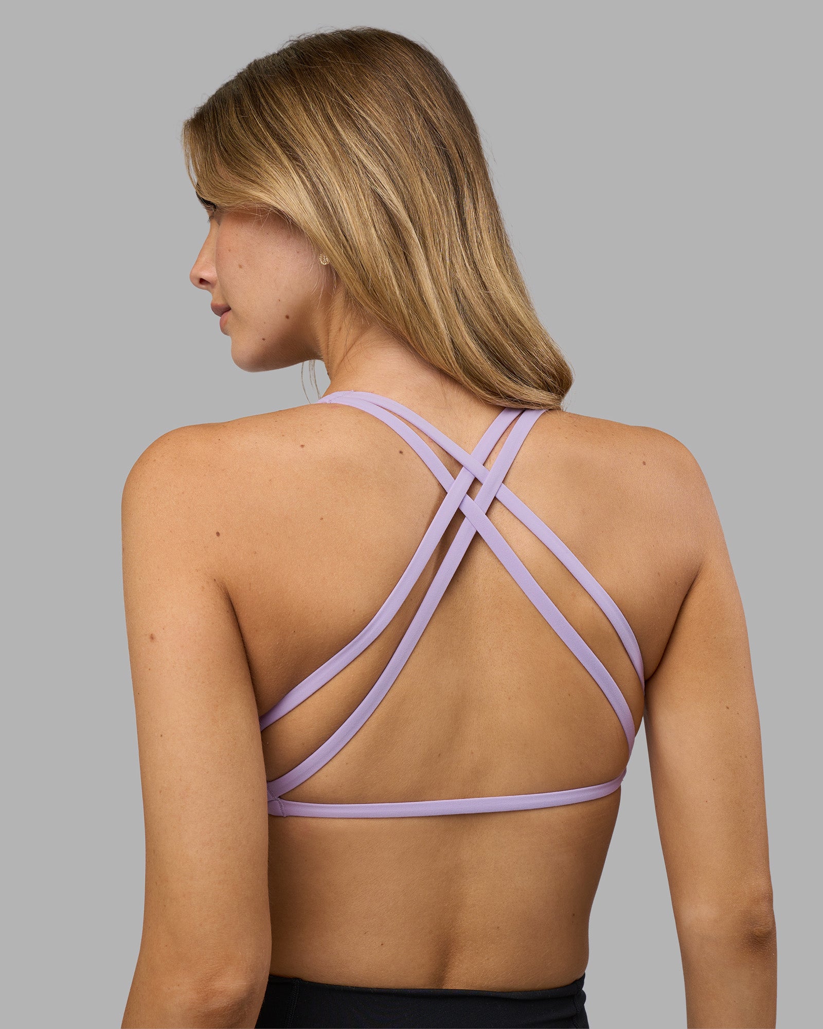 Woman wearing Aspire Twist Sports Bra - Pale Lilac | Model:Leilani | Size:XS