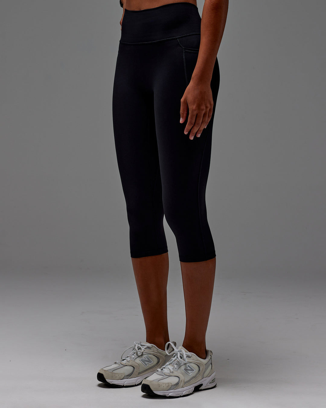Woman wearing Fusion Ultra High-Rise 3/4 Legging Pockets - Black | Model:Txai | Size:XS