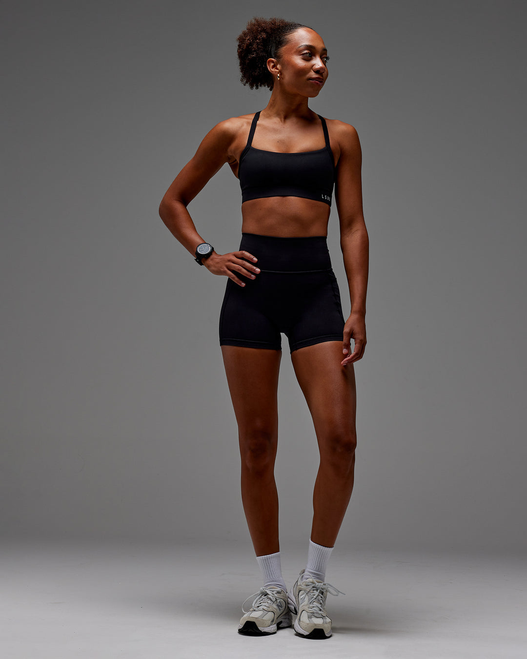 Woman wearing Fusion Ultra High-Rise 4" Short Pockets - Black | Model:Txai | Size:XS