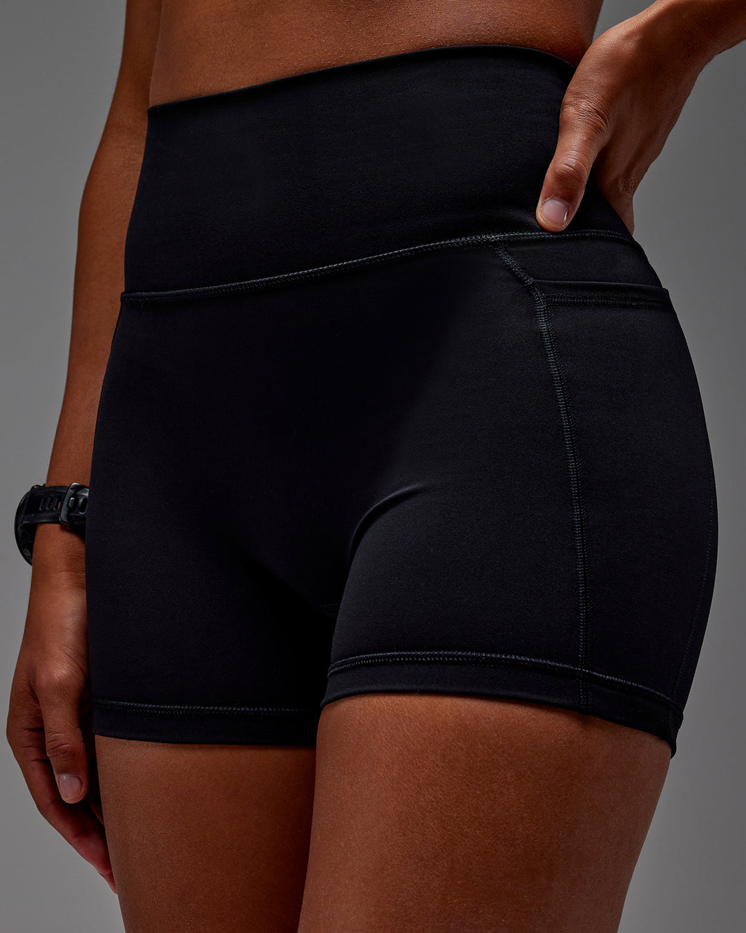 Woman wearing Fusion Ultra High-Rise 4" Short Pockets - Black | Model:Txai | Size:XS