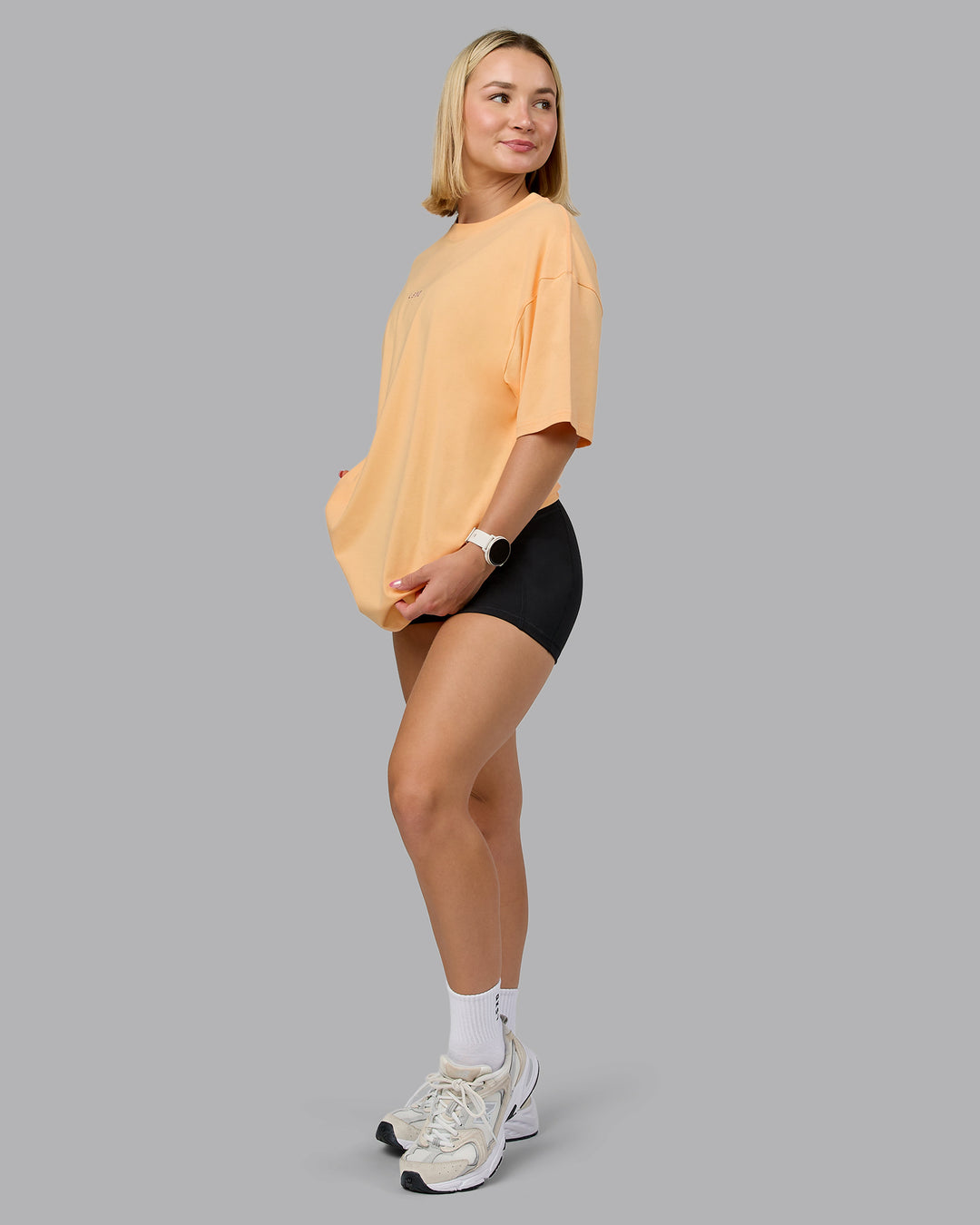 Woman wearing On Repeat FLXCotton Oversized Tee - Peach Fuzz-White | Model:Halle | Size:XS