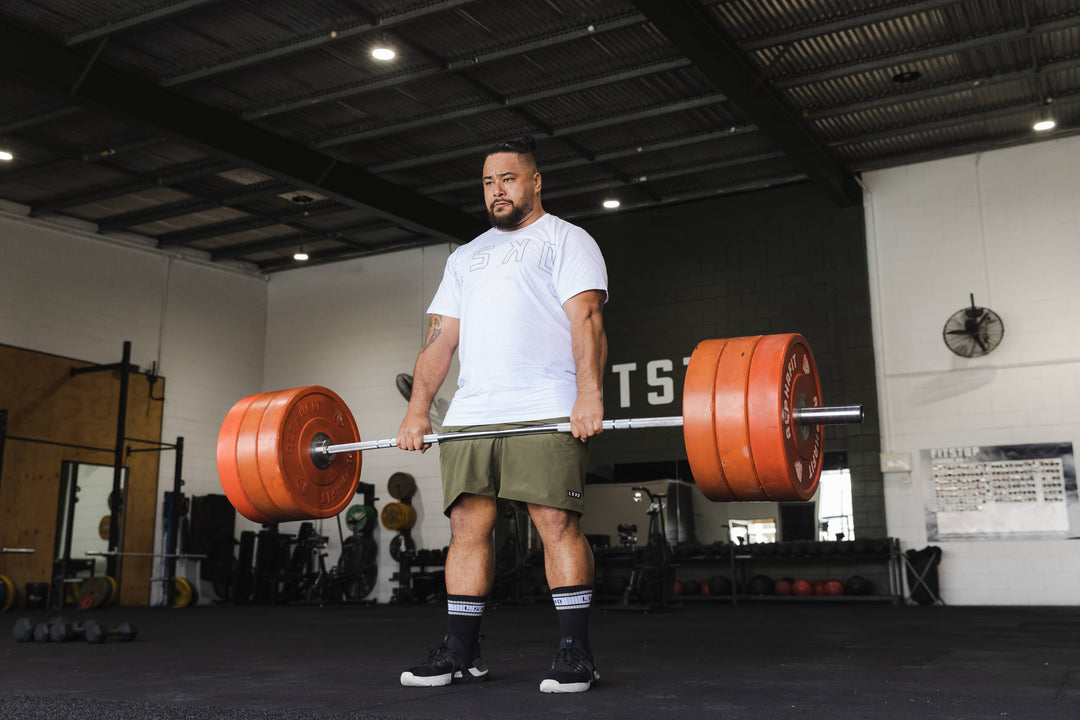 man deadlifting barbell of weights