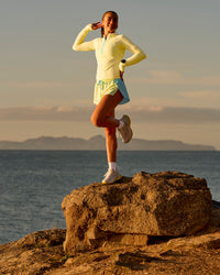 Woman wearing GG AeroFLX+ Long Sleeve Half Zip - Lemon-Baltic Sea | Model:Grace | Size:XS