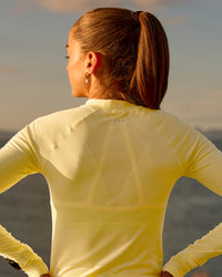 Woman wearing GG AeroFLX+ Long Sleeve Half Zip - Lemon-Baltic Sea | Model:Grace | Size:XS