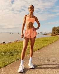 Woman wearing Velocity Sports Bra - Cantaloupe | Model:Zara | Size:2XS