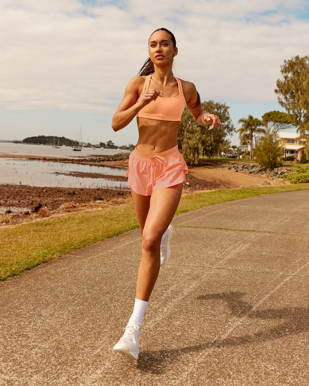Woman wearing Velocity Sports Bra - Cantaloupe | Model:Zara | Size:2XS