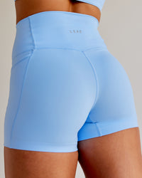 Woman wearing Abs Elixir Ultra High-Rise 4" Short Pockets - Open Air