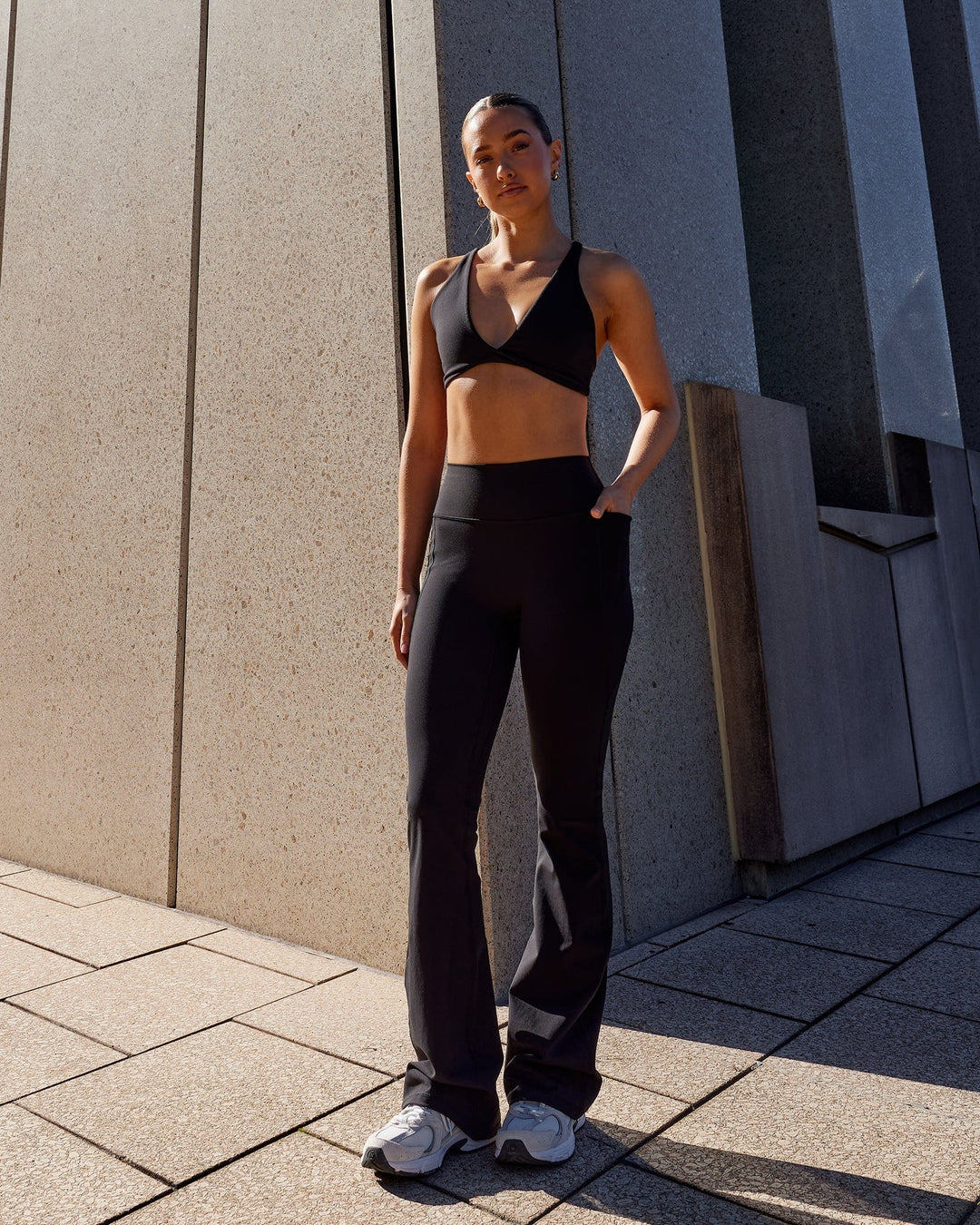 Woman wearing Fusion Ultra High-Rise Flared Legging Pockets - Black | Model:Grace | Size:S