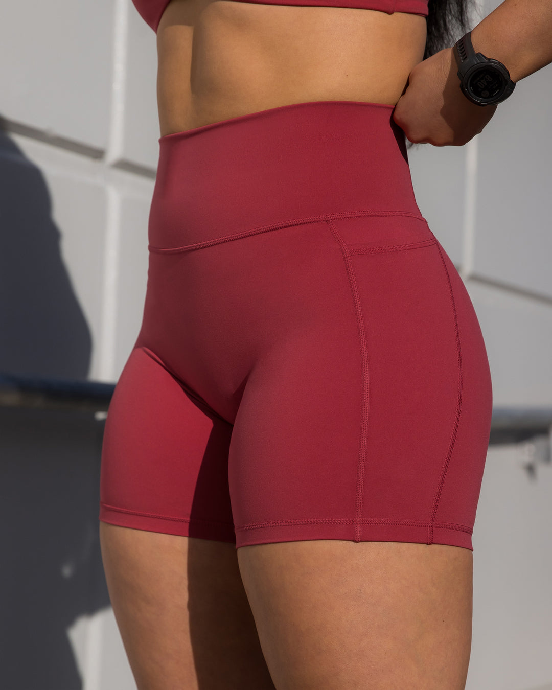 Woman wearing Fusion Ultra High-Rise 4&quot; Short Pockets - Claret | Model:Bailey | Size:S